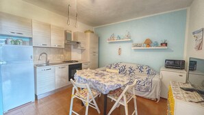 Eine kompakte Küche mit Essbereich, Deckenventilator und Mikrowelle.