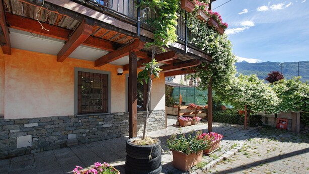 A building with a stone facade, wooden beams, and a balcony with potted plants. - Apartment 'Chateau Chatillon' with Mountain View, Private Terrace and Wi-Fi (Châtillon)
