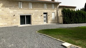 A stone building with a tiled roof, a door, and a window.
