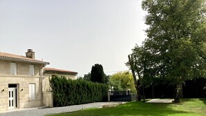 A building with a stone facade, a gravel driveway, and a well-maintained lawn.