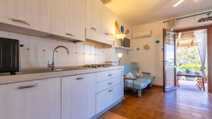 Una cocina moderna con estufa integrada, un lavamanos y un comedor con mesa y sillas.