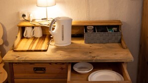 Un comptoir de cuisine en bois, avec une bouilloire, une lampe et une boîte de rangement.