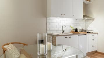 Een koelkast, een kookplaat, een waterkoker, kookgerei, borden en bestek