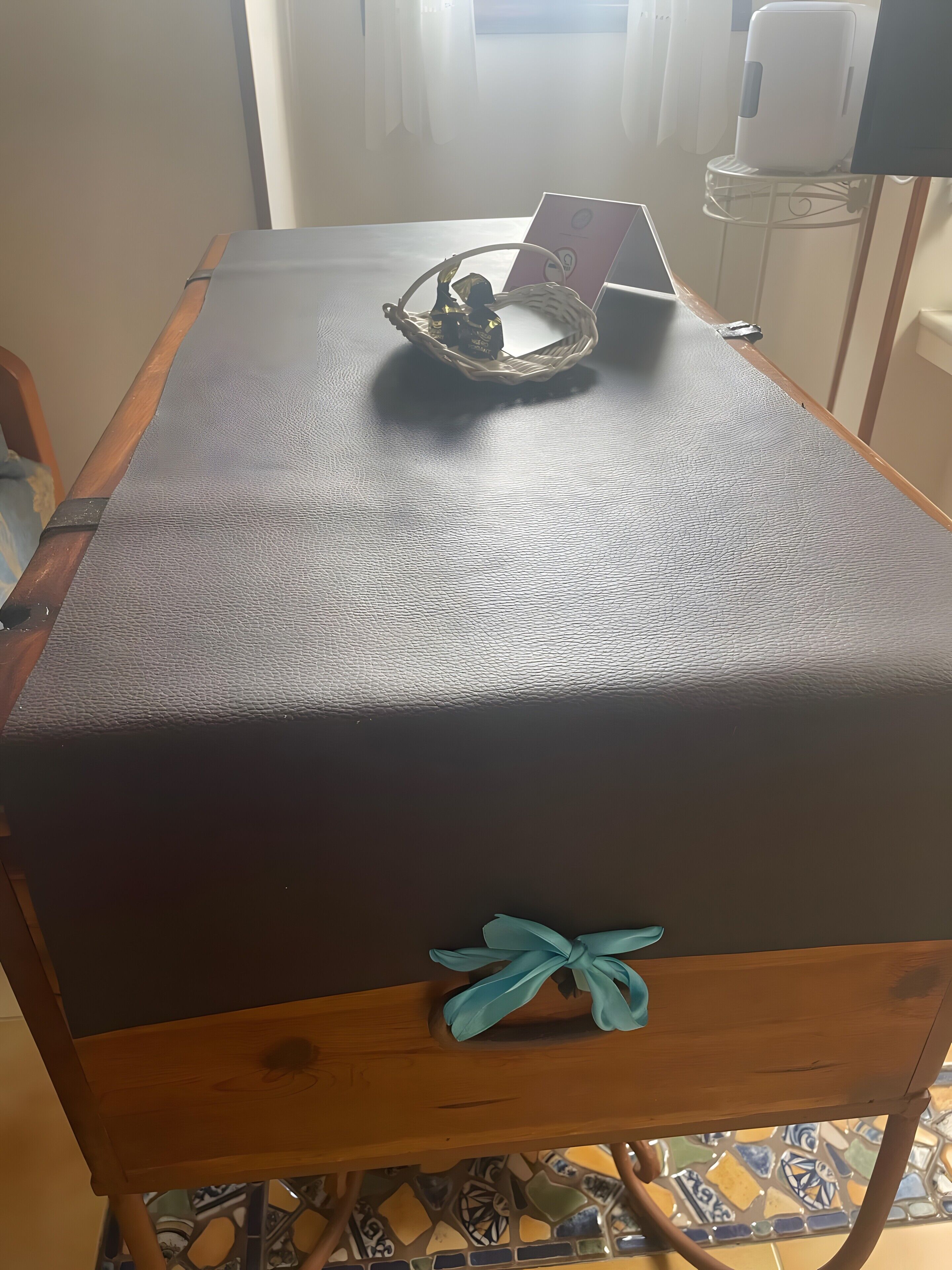 Ein Zimmer mit Tisch, Korb, Laptop und einer Dekoration auf dem Tisch.