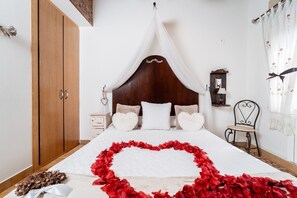 A bedroom with a canopy bed, a wooden wardrobe, a nightstand, and a chair. - Room 'Doble Confort Dalia' with Mountain View, Shared Terrace and Wi-Fi (Rubayo)