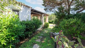 A garden pathway leading to a white building with a pergola. - Holiday Home 'Medit' with Private Terrace, Wi-Fi and Air Conditioning (Stintino)