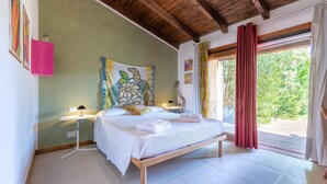 A bedroom with a bed, bedside tables, a painting, and a view through a window. - Holiday Home 'Medit' with Private Terrace, Wi-Fi and Air Conditioning (Stintino)