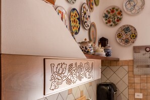 A kitchen with a decorative backsplash, a coffee machine, and a wall-mounted calendar.