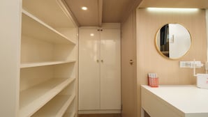 A small, well-lit room with a white wardrobe, a round mirror, and a white countertop. - Great Holiday Vacation: 1BR Condo w/ 2 Queen Beds (Quezon City)