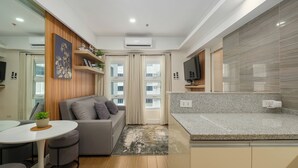 A modern kitchen with a granite countertop, a built-in oven, and a microwave. - Great Holiday Vacation: 1BR Condo w/ 2 Queen Beds (Quezon City)