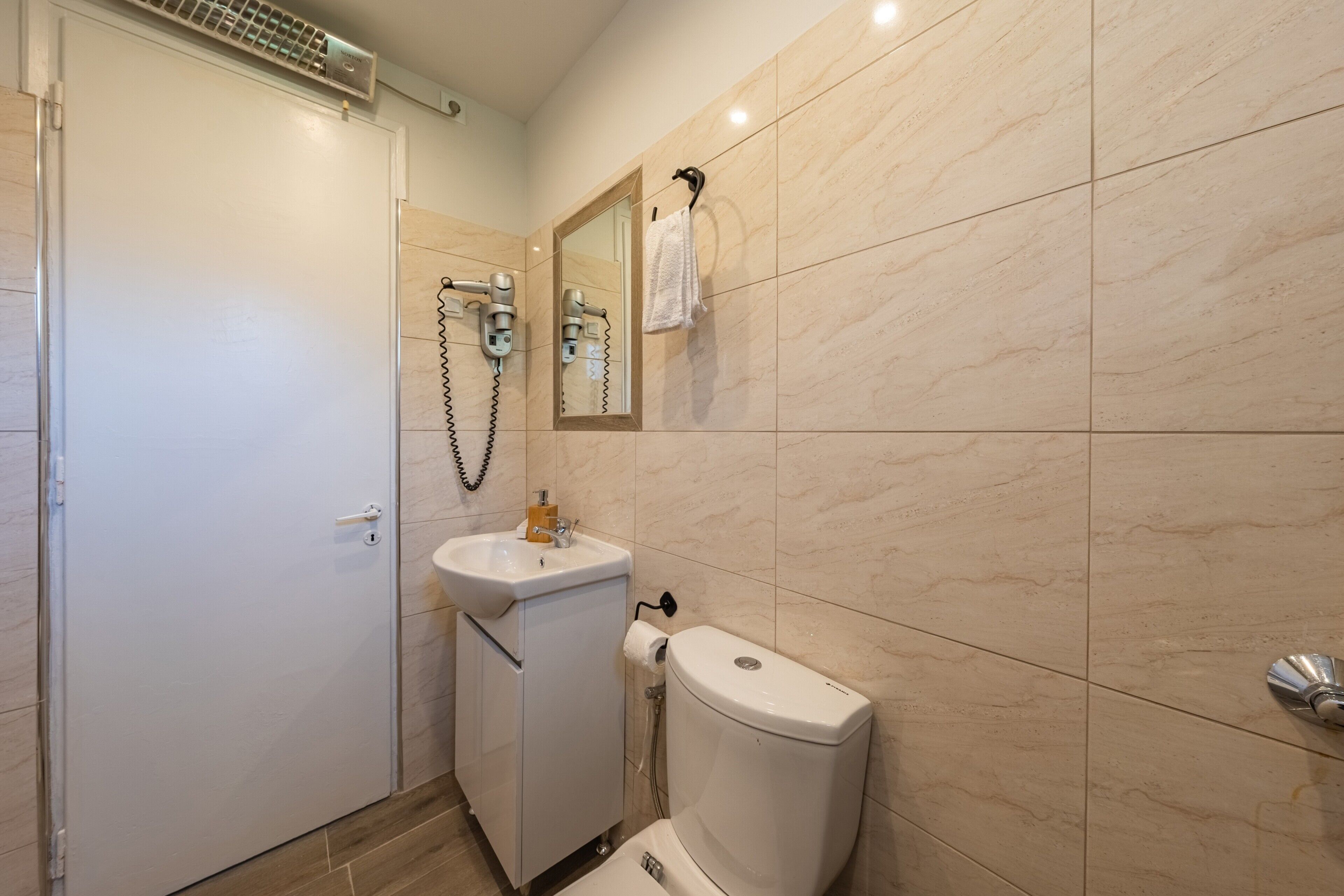 A bathroom with a toilet, sink, and shower.
