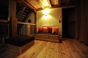 Un intérieur en bois avec un lit, un radiateur et un escalier.