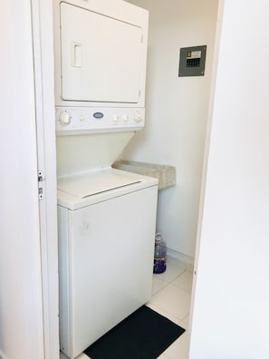A compact laundry room with a front-loading washing machine and a dryer.