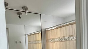 A bathroom with a toilet, sink, and a large mirror.