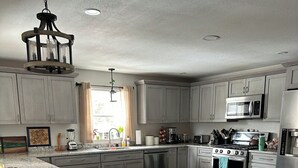 Una cocina moderna con encimeras de granito, electrodomésticos de acero inoxidable y una isla grande con banco.