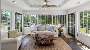 A sunroom with a white ceiling, a ceiling fan, and large windows overlooking a backyard with a pool. - Heated Pool, Hot Tub, Game Room, EV charger, Sleeps 20 (Lawrenceburg)