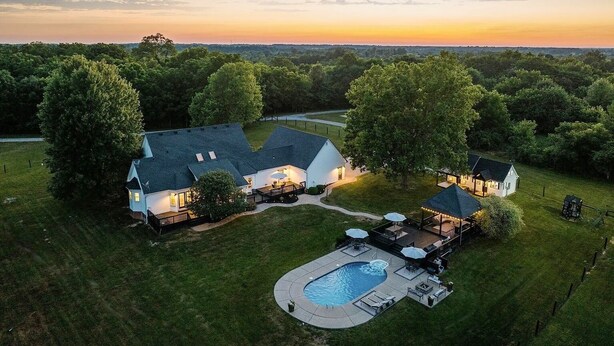 A large house with a swimming pool, surrounded by a well-maintained lawn and trees. - Heated Pool, Hot Tub, Game Room, EV charger, Sleeps 20 (Lawrenceburg)
