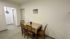 Un comedor con una mesa, sillas, un reloj y una puerta.