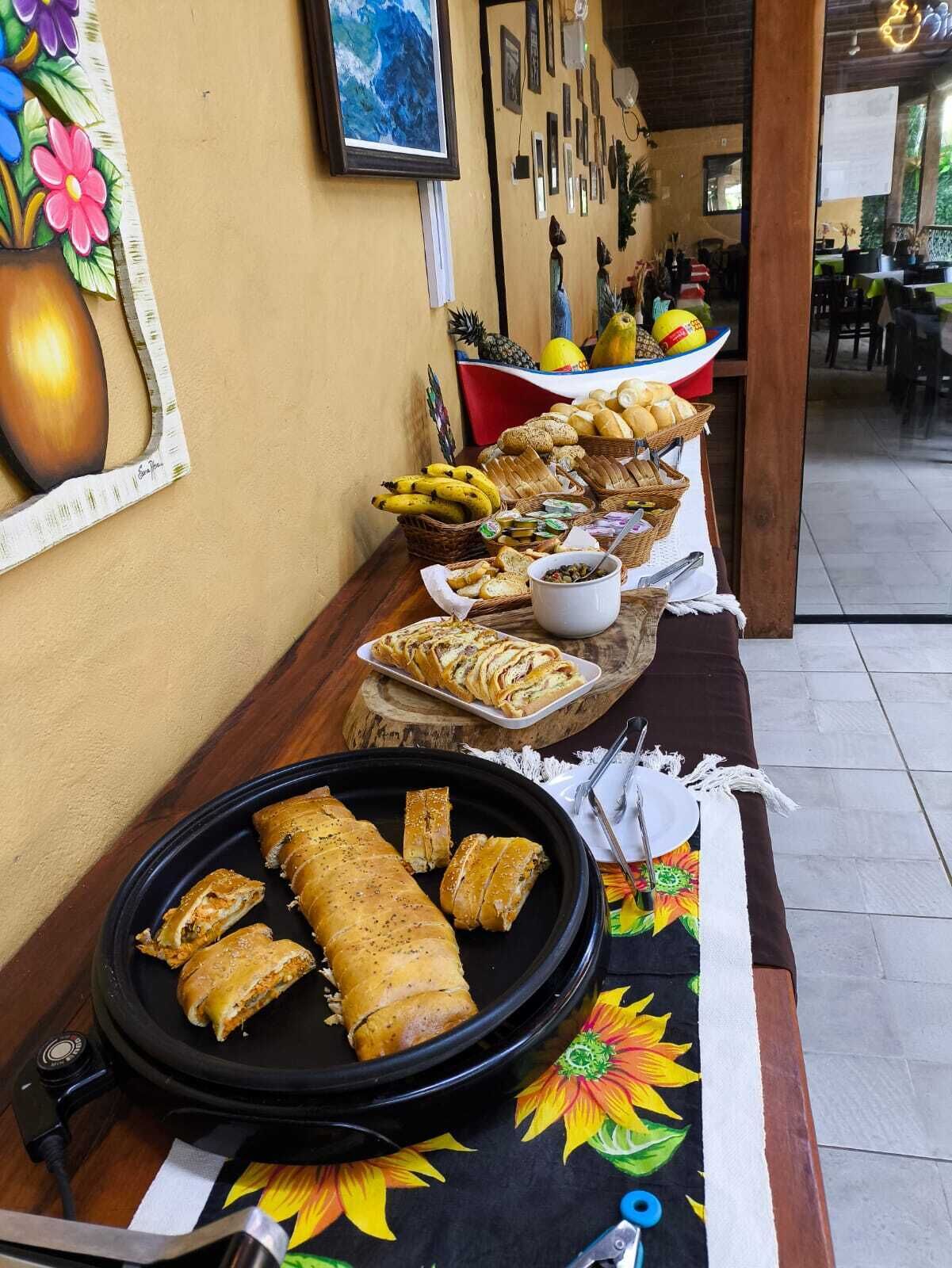Taula de buffet amb diferents plats i una paret decorativa amb obres d'art.