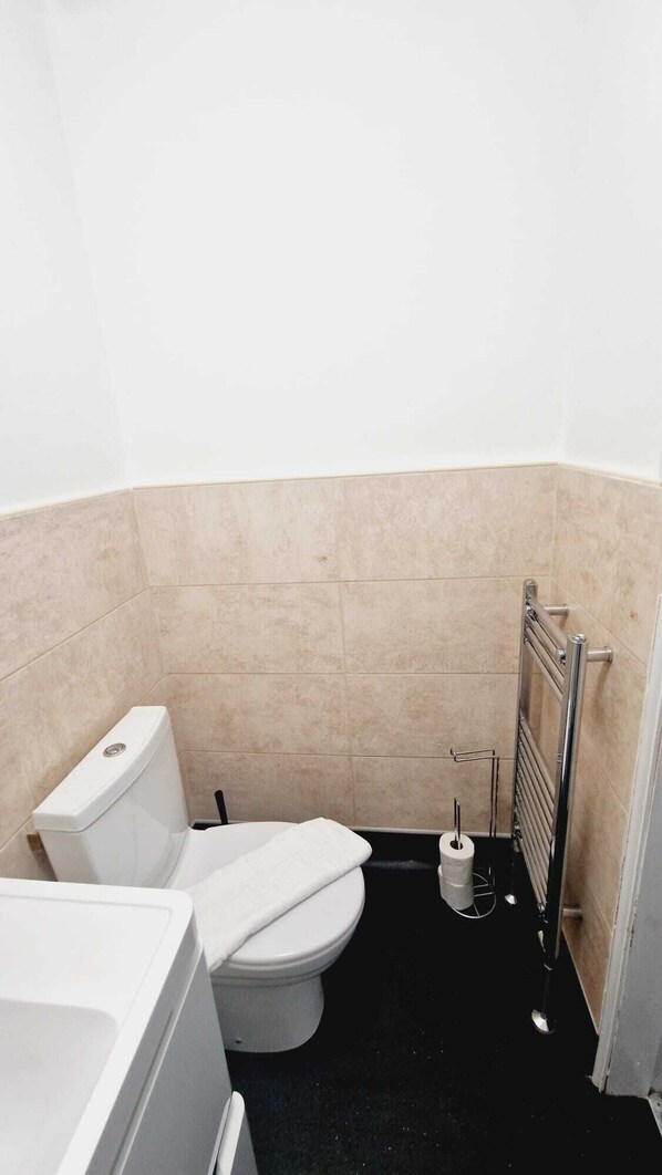 Un baño pequeño y funcional con inodoro, bidé y bañera.