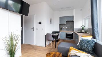 A modern living room with a sofa, a coffee table, and a TV mounted on the wall.