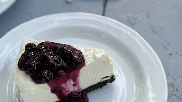 A slice of cheesecake with a cherry topping on a white plate.