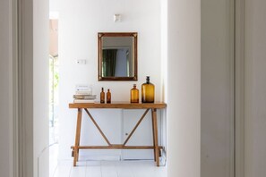 A hallway with a wooden console table, a mirror, and a few books. - Charming Villa with Private Pool immersed in the greenery of Chianti (Panzano In Chianti)