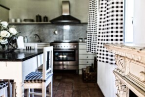 A kitchen with a central island, a stove, and a sink.