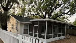 A single-story house with a covered porch and a white picket fence.