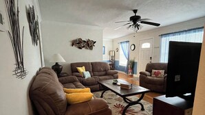A living room with a brown sofa, a coffee table, and a television.
