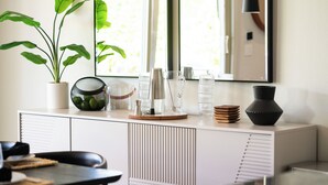 A modern kitchen with a white cabinet, a potted plant, and various kitchenware. - Paseo Palms, Modern 6br home 5min to Polo Grounds (Coachella)