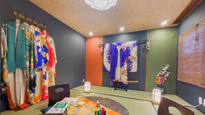 A traditional Japanese room with tatami flooring, a shoji screen, and a futon bed.
