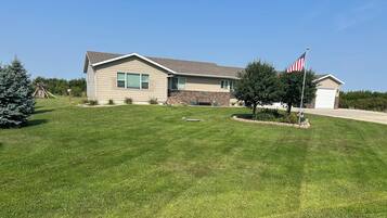 Ein Wohnhaus mit gepflegtem Rasen, einem Fahnenmast mit der US-amerikanischen Flagge und einer Ziegelgarage.