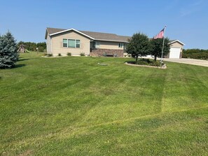 Ein Wohnhaus mit gepflegtem Rasen, einem Fahnenmast mit der US-amerikanischen Flagge und einer Ziegelgarage.