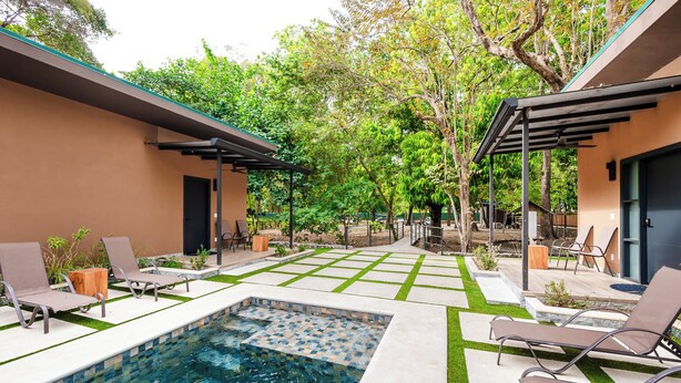 A swimming pool with lounge chairs and a pergola, surrounded by a garden and trees. - Private Tropical Villa with Backyard • Pool • Fast WiFi • Self Check-In (Provincia de Guanacaste)