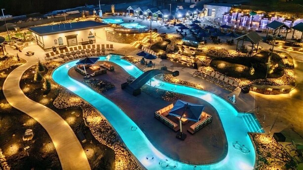 Un resort con piscina, zonas de descanso y un edificio con múltiples ventanas.