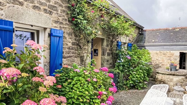 A stone building with blue shutters, a garden with pink hydrangeas, and outdoor seating. - Maison de Langonnet by Interhome (Langonnet)