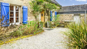 A stone building with blue shutters, a gravel path, and greenery. - Maison de Langonnet by Interhome (Langonnet)
