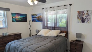 Ein Schlafzimmer mit einem Bett, zwei Nachttischen, einer Kommode und Bildern an den Wänden.
