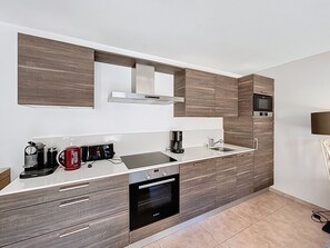 A modern kitchen with a built-in oven, a microwave, and a coffee maker. - Charme - Les Gets - Les Perrières (Les Gets)