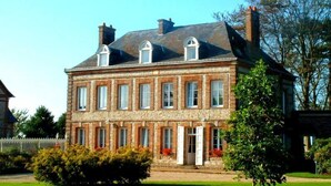 A two-story stone building with a symmetrical facade, multiple windows, and a central entrance.