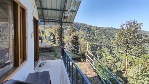 Ein Balkon mit Blick auf ein grünes Tal und Hügel.
