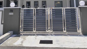 A modern building with a gated entrance, numbered 70, and multiple windows. - ForgetMeNot Pangkor Homestay 70 小蓝花民宿  4-bedroom villa with WiFi, AC (Pangkor)