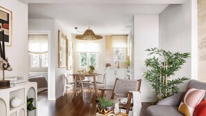 Un salon moderne avec un canapé, un coin repas et une cuisine en arrière-plan.