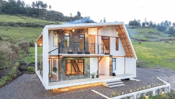 A modern two-story house with a stone facade, large windows, and a balcony. - Cari House Mountain View Near Volcano (Salinas)