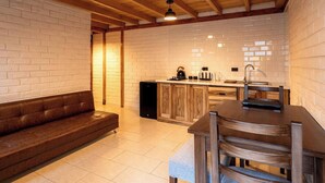 A cozy kitchen with a wooden bench, a dining table, and a built-in oven. - Cari House Mountain View Near Volcano (Salinas)