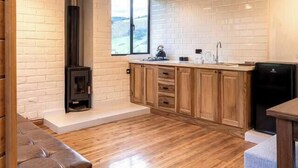 Una cocina amplia con armarios de madera, estufa integrada y un ventanal grande.