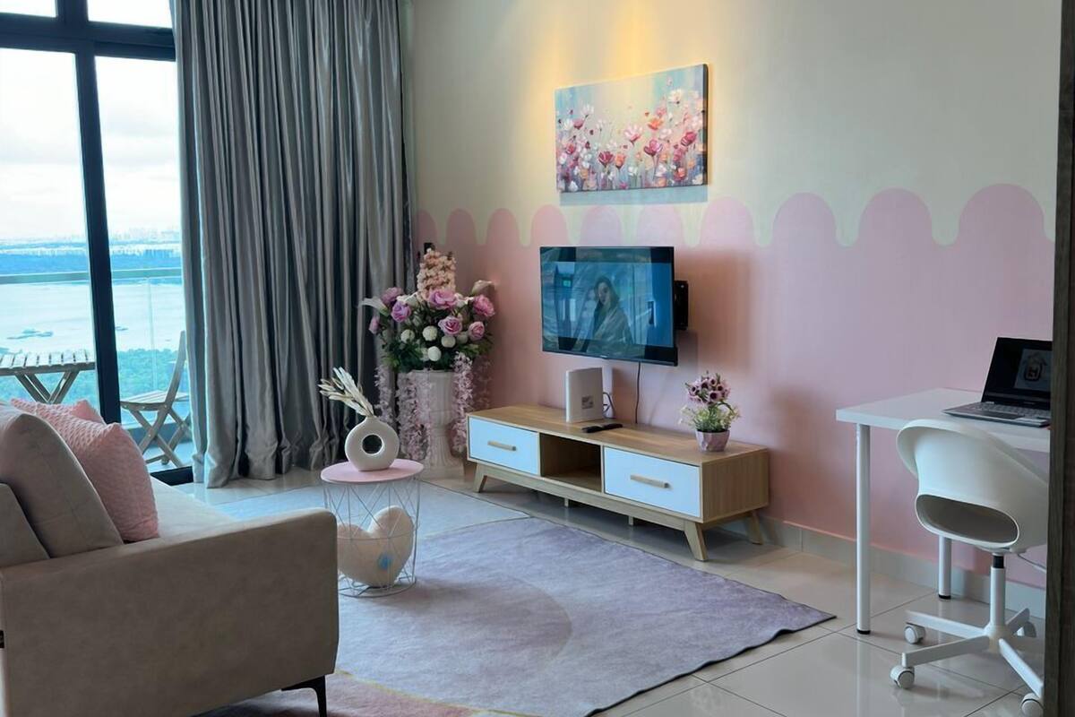 A modern living room with a sofa, TV, and desk area.