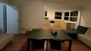 A compact living space with a kitchenette, a dining area, and a sofa.