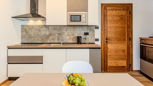 A modern kitchen with a built-in microwave, stainless steel sink, and wooden cabinets.